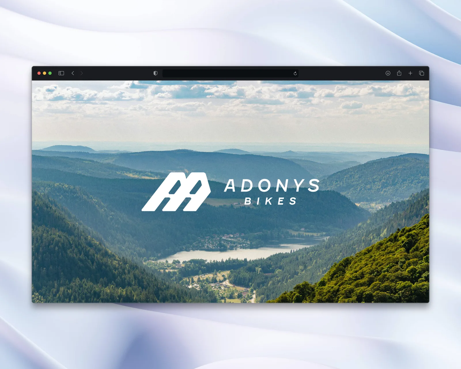 Page d'accueil du site Adonys Bikes, logo blanc sur une vallée boisée
