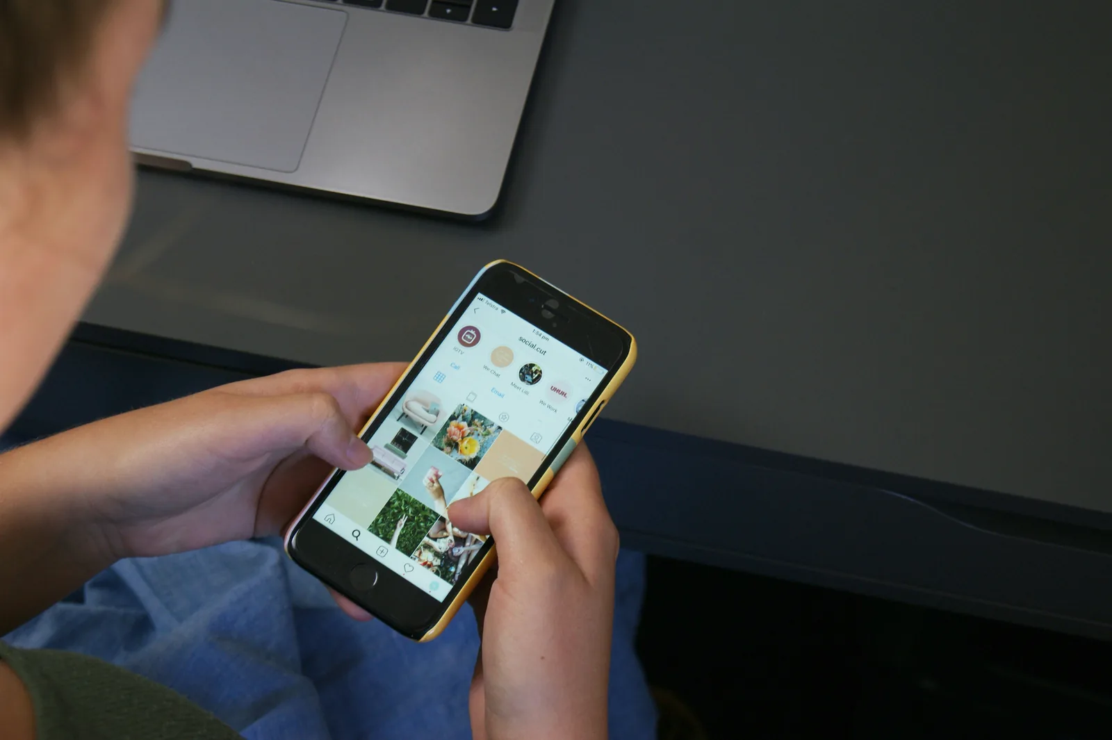 Main tenant un smartphone ouvert sur l'application « social.cut »